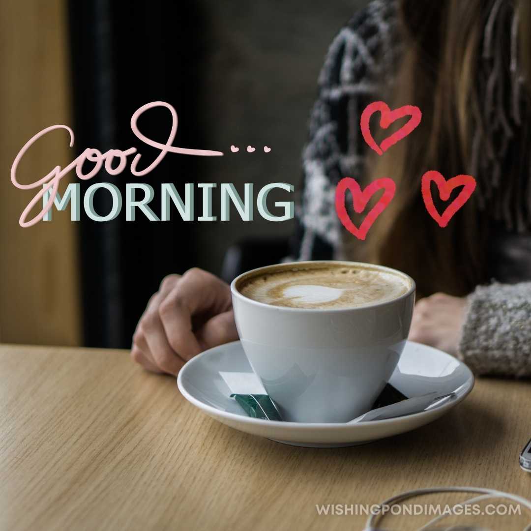 A girl sitting in the Caffe with cup of coffee on the table. Good Morning Coffee Images